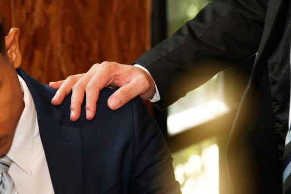 man holder hånd på skulderen af ven